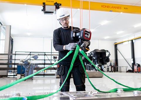 Crane operator attaches sling to hook