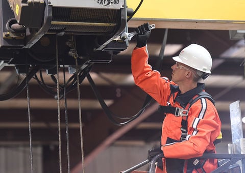 Konecranes technician uses wrench while inspecting hoist